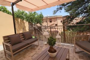 un patio con 2 divani e un tavolo sul balcone di BeB Omare Agrigento a Agrigento