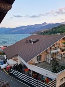 a house with a roof and a body of water at Hotel Chalet Bellerive in Spiez