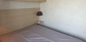 um quarto com uma cama com um candeeiro em Première ligne mer Appartement t2 pour 4 personnes N2 101 em La Grande-Motte