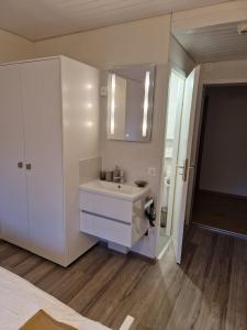 a white bathroom with a sink and a mirror at Hotel Chalet Bellerive in Spiez