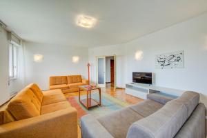 een woonkamer met 2 banken en een tv bij Margherita near lake-child friendly - Happy Rentals in Toscolano Maderno