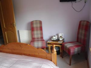a bedroom with two chairs and a table and a bed at Arisaig Guest House in Inverness