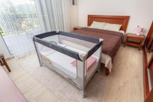 a baby crib in a bedroom with a bed at Apartments Horizont in Budva