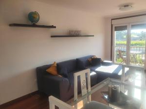 a living room with a blue couch and a glass table at Nueva vista in Pontevedra