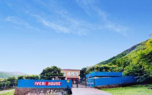 un bâtiment bleu avec un panneau indiquant la nouvelle maison dans l'établissement Iveri House, à Koutaïssi