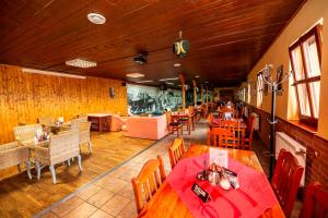 un restaurante con paredes de madera, mesas y sillas en Penzion Myslivna, en Lednice