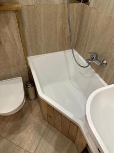 een badkamer met een wastafel, een bad en een toilet bij ApartmentTallinas70B in Rīga