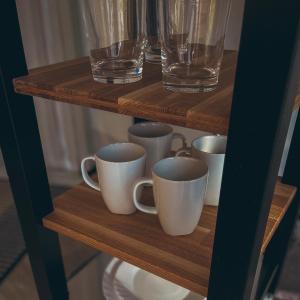 a group of cups and glasses on a wooden shelf at Greenery Kupolai 