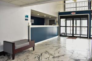 eine Lobby mit einer Bank in der Mitte eines Gebäudes in der Unterkunft Clarion Pointe Vidalia - Lyons West in Vidalia