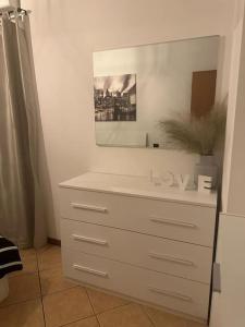 a white dresser with a mirror on top of it at Indomabile Home Como in Cantù