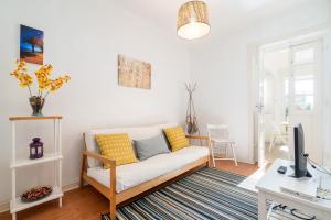 a living room with a couch and a tv at Covelo Park Apartment in Porto