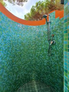 a green tiled bathroom with a shower at Le Due Tortore Home Holiday - Villa con splendido giardino ad un minuto a piedi dal mare in Forte Village