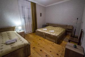 deux lits dans une chambre avec parquet dans l'établissement house by the river, à Mestia