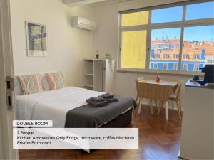 a bedroom with a bed and a table and a window at Studio 59 Lisboa in Lisbon