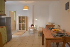 a kitchen and living room with a table and a refrigerator at Afroditi's Garden View in Batsi