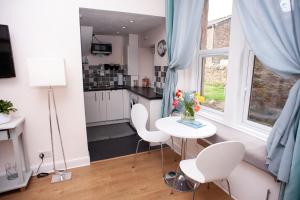 a kitchen with a table and chairs and a window at Bees Townhouse- Cupar in Cupar