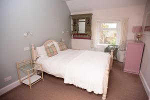 a bedroom with a white bed and a window at Bees Townhouse- Cupar in Cupar