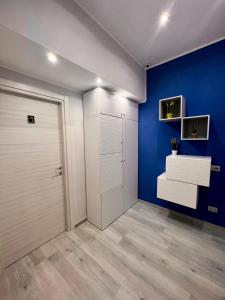een kamer met een witte kast en een blauwe muur bij punto house in Napels