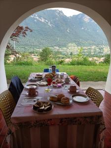 a table with food on it with a view of a mountain at B&B le rose in Crone