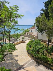 a stone walkway leading to a house with a view of the water at Villa Renata in Pirovac