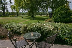 a glass table and two chairs on a patio at Dryfesdale Hotel - BW Signature Collection in Lockerbie