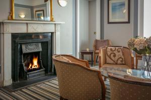 a living room with a fireplace and a table and chairs at Dryfesdale Hotel - BW Signature Collection in Lockerbie