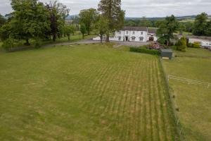 duże pole trawy z domem w tle w obiekcie Dryfesdale Hotel - BW Signature Collection w mieście Lockerbie
