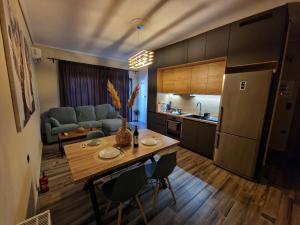 a kitchen and living room with a table and a refrigerator at artemis apartment in Agria