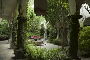 a garden with a fountain and trees and plants at Casa Mision de San Miguel in San Miguel de Allende