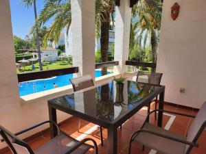 a dining room with a table and chairs and a pool at costa ballena elite in Costa Ballena