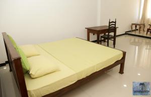 sypialnia z łóżkiem, stołem i krzesłem w obiekcie Jayananda Estate Villa w mieście Dickwella