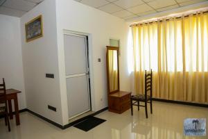 a room with a door and a table and chairs at Jayananda Estate Villa in Dickwella