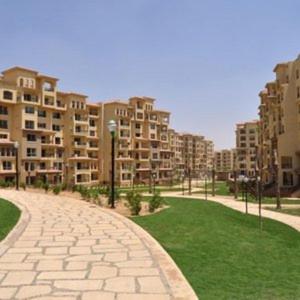 a brick path in a city with tall buildings at جراند هاوس مدينتى in Madinaty +10 photos