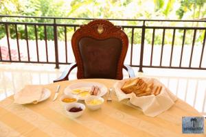 a table with a plate of eggs and bread on it at Jayananda Estate Villa in Dickwella