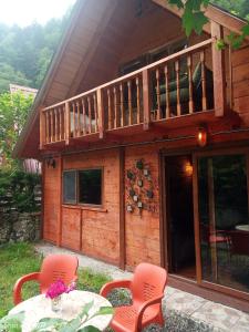 a house with a deck and two chairs and a table at MJORA Bungalov Ayder in Güroluk