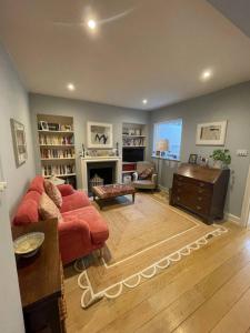 a living room with a red couch and a fireplace at Beautiful Family-Friendly 4BD House - North Sheen in Kew Gardens