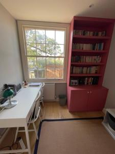 an office with a desk and a window and a book shelf at Beautiful Family-Friendly 4BD House - North Sheen in Kew Gardens