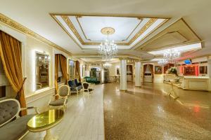 イスタンブールにあるホテル イペック パラスのシャンデリアとリビングルームが備わる広い客室です。