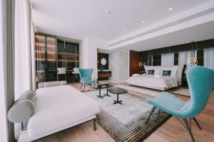 a living room with a bed and a table and chairs at Empire Beach Resort ADULTS ONLY in Dhërmi +37 photos