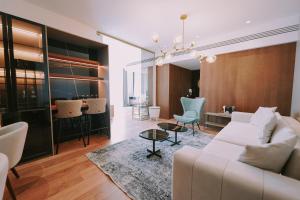 a living room with a white couch and a table at Empire Beach Resort ADULTS ONLY in Dhërmi