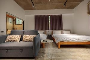 a living room with a couch and a bed at 魚池白宮458 in Yuchi