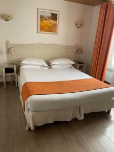 a bedroom with a large bed with two pillows at H&ocirc;tel Le M&eacute;di&eacute;val Palais des Papes in Avignon