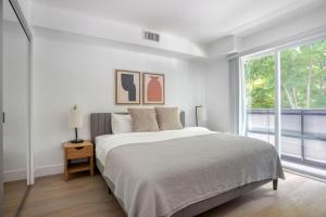 a white bedroom with a large bed and a window at Brentwood 1br w gym rooftop nr shops bars LAX-1076 in Los Angeles