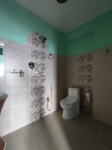 a bathroom with a toilet and a shower stall at Sarangkot Hotel New Galaxy in Pokhara