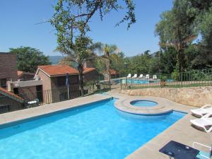 ein großer Pool mit Stühlen im Hof in der Unterkunft Hotel La Colina del Sol in Villa Carlos Paz