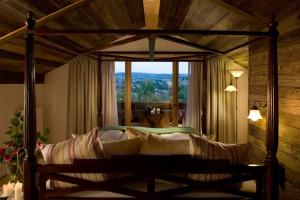 a bedroom with a canopy bed with a large window at BollAnts Spa im Park in Bad Sobernheim +93 photos