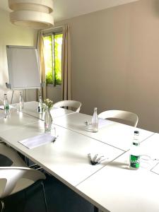 uma sala de reuniões com uma mesa branca e cadeiras em La Quietat em Toulouse