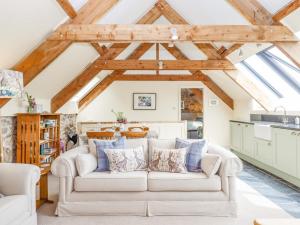 una sala de estar con un sofá blanco en una habitación en The Coach House at Thorn Farm, en Exeter