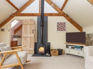 a living room with a fireplace and a tv at The Coach House at Thorn Farm in Exeter