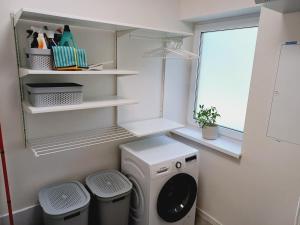a laundry room with a washing machine and two trash cans at Domy 200m od pláže s terasou na grilování priamo na Slnečných jazerach Senec in Senec